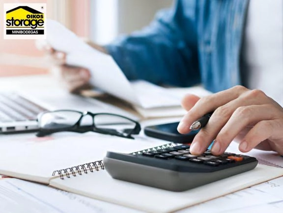 Beneficios fiscales para empresas que usan Minibodegas para almacenar inventario Persona con elementos de oficina